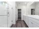 Modern bathroom with double vanity, glass shower, and grey wood-look floors at 3600 W Cobalt Ct, San Tan Valley, AZ 85144