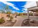 A backyard with a covered patio and stone pavers featuring desert landscaping at 6546 W Georgetown Way, Florence, AZ 85132