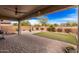 A backyard with a covered patio, stone pavers and synthetic grass at 6546 W Georgetown Way, Florence, AZ 85132