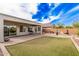 A backyard features a covered patio, grill, desert landscaping and stone pavers at 6546 W Georgetown Way, Florence, AZ 85132