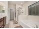 Bright bathroom with a glass-enclosed shower, soaking tub, and neutral color scheme at 6546 W Georgetown Way, Florence, AZ 85132