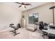 A bedroom with a ceiling fan features a work out bench and a work desk at 6546 W Georgetown Way, Florence, AZ 85132