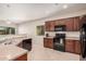 Modern kitchen boasts dark wood cabinets, black appliances, and stylish countertops at 6546 W Georgetown Way, Florence, AZ 85132