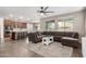 Open concept living room with L-shaped sectional and kitchen at 6943 N 88Th Dr, Glendale, AZ 85305