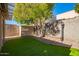 Landscaped backyard with artificial turf and covered patio at 7046 W Mercer Ln, Peoria, AZ 85345