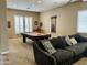 Spacious living room featuring a pool table, cozy seating area, and plantation shutters for ample natural light at 861 E Toledo St, Gilbert, AZ 85295