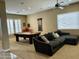 Well-lit living room with a pool table, comfortable sectional sofa, and large windows with plantation shutters at 861 E Toledo St, Gilbert, AZ 85295