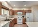 Kitchen with wood cabinets, white appliances, and a double sink at 878 E Cherry Hills Dr, Chandler, AZ 85249