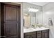 Double vanity bathroom with dark brown cabinets and a large mirror at 12756 W Caraveo Pl, Peoria, AZ 85383