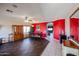 Bright dining area with dark wood floors and red accent wall at 21925 N 78Th Dr, Peoria, AZ 85383