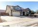 Two-story house with beige exterior, three-car garage, and driveway at 22235 E Munoz Ct, Queen Creek, AZ 85142