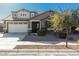 Two-story house with a beige exterior, a three-car garage, and landscaping at 22235 E Munoz Ct, Queen Creek, AZ 85142