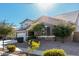 Two-story house with beige exterior, three-car garage, and mature trees at 22235 E Munoz Ct, Queen Creek, AZ 85142