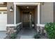 Inviting front entry with a dark wooden door, stone accents, and landscaping at 22235 E Munoz Ct, Queen Creek, AZ 85142