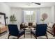 Modern living room with brown leather sofas, blue armchairs, and wood flooring at 22235 E Munoz Ct, Queen Creek, AZ 85142