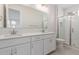 Modern bathroom featuring a double sink vanity, shower with glass door and tile surround at 2917 N Evergreen St, Buckeye, AZ 85396
