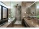 Bathroom with concrete walls, dual sinks, and walk-in shower at 38300 N 102Nd St, Scottsdale, AZ 85262