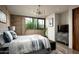 Modern bedroom with concrete accent wall, large window, and flat screen TV at 38300 N 102Nd St, Scottsdale, AZ 85262