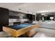 Modern game room featuring a pool table, fireplace, and adjacent wet bar at 38300 N 102Nd St, Scottsdale, AZ 85262