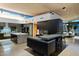 A modern kitchen with marble counters and dark cabinets connects to a dining area and outdoor views at 38300 N 102Nd St, Scottsdale, AZ 85262