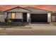 Inviting exterior featuring a stone facade, covered porch, and a well-maintained landscape at 4041 S 176Th Dr, Goodyear, AZ 85338