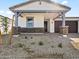 Inviting exterior featuring a stone facade, covered porch, and a well-maintained landscape at 4041 S 176Th Dr, Goodyear, AZ 85338