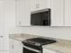 Detailed view of a modern kitchen featuring granite countertops, stainless steel appliances, and white cabinets at 4041 S 176Th Dr, Goodyear, AZ 85338