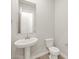 Powder room featuring a pedestal sink, wood-look floors, and modern fixtures at 4822 N 177Th Ln, Goodyear, AZ 85395