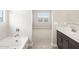 Bathroom offers soaking tub, view to bedroom, dual sink vanity with modern fixtures at 4822 N 177Th Ln, Goodyear, AZ 85395