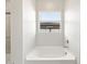 Bright and modern bathroom features a soaking tub with a view from the window at 4822 N 177Th Ln, Goodyear, AZ 85395