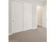 A bright bedroom features neutral carpet and a closet with sliding doors for ample storage at 4822 N 177Th Ln, Goodyear, AZ 85395