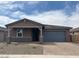 Charming single-story home featuring a covered porch, two car garage, and desert landscaping at 4822 N 177Th Ln, Goodyear, AZ 85395