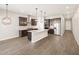 Open kitchen features a center island, dark cabinetry, stainless appliances, and stylish pendant lighting at 4822 N 177Th Ln, Goodyear, AZ 85395