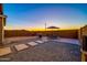Spacious backyard with patio, table, umbrella, and grill at sunset at 5932 S 26Th Ave, Phoenix, AZ 85041