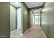 Long hallway with green walls and wood-look tile floors at 5932 S 26Th Ave, Phoenix, AZ 85041