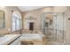 Bright bathroom featuring a soaking tub, glass enclosed shower with tile surround, and arched window at 6178 W Quail Ave, Glendale, AZ 85308