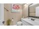 Powder room featuring a pedestal sink, decorative mirror, art work, and modern fixtures at 6178 W Quail Ave, Glendale, AZ 85308