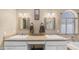 Bright bathroom featuring double sinks, granite counters, decorative mirrors, and a garden window for natural light at 6178 W Quail Ave, Glendale, AZ 85308