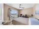 Cozy bedroom with ceiling fan, plush carpet, bright window and dresser with TV and lamp at 6178 W Quail Ave, Glendale, AZ 85308