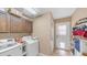 Well-equipped laundry room with washer, dryer, storage cabinets, and access to the backyard at 6178 W Quail Ave, Glendale, AZ 85308