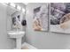 Modern powder room with pedestal sink and artistic wall decor at 7117 E Rancho Vista Dr # 3006, Scottsdale, AZ 85251