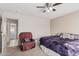 Bedroom with king-size bed, recliner, and access to hallway at 9041 W Virginia Ave, Phoenix, AZ 85037