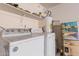 Interior laundry room with washer, dryer, and storage shelves at 9041 W Virginia Ave, Phoenix, AZ 85037