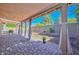 Covered patio with pavers and curtains, overlooking a grassy backyard at 10405 N 65Th Dr, Glendale, AZ 85302