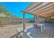 Covered patio with pergola, table, chairs and curtains, overlooking a grassy backyard at 10405 N 65Th Dr, Glendale, AZ 85302