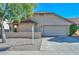 House exterior showcasing a two-car garage and desert landscaping at 10405 N 65Th Dr, Glendale, AZ 85302