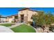 Tan two-story house with a three car garage and artificial turf at 21122 W Edgemont Ave, Buckeye, AZ 85396