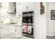 Modern kitchen with double oven, granite countertops, and white shaker cabinets at 21122 W Edgemont Ave, Buckeye, AZ 85396