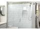 Bright white tiled shower with glass enclosure and built-in seat at 21122 W Edgemont Ave, Buckeye, AZ 85396