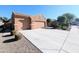 Three-car garage with a long driveway and desert landscaping at 21209 N 40Th Ave, Glendale, AZ 85308